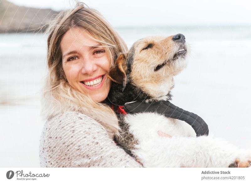 Frau umarmt Foxterrier am Meer Fox-Terrier Hund Streicheln Eckzahn Umarmung Haustier Liebe Porträt Kraulen Bonden Umarmen Zuneigung freie Zeit Wochenende MEER