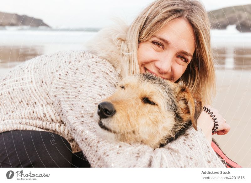 Frau umarmt Foxterrier am Meer Fox-Terrier Hund Streicheln Eckzahn Umarmung Haustier Liebe Porträt Kraulen Bonden Umarmen Zuneigung freie Zeit Wochenende MEER