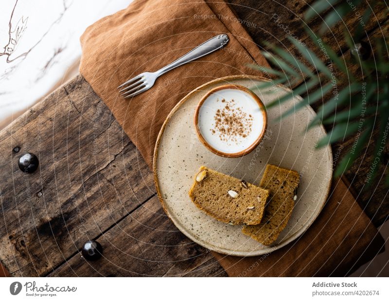 Scheiben Vollkornbrot, serviert auf einem Teller mit Milchbecher Brotlaib melken heilsam Snack gebacken geschmackvoll frisch Kürbis appetitlich Samen Gebäck