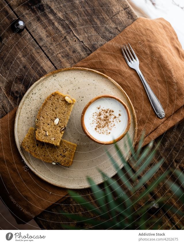 Scheiben Vollkornbrot, serviert auf einem Teller mit Milchbecher Brotlaib melken heilsam Snack gebacken geschmackvoll frisch Kürbis appetitlich Samen Gebäck