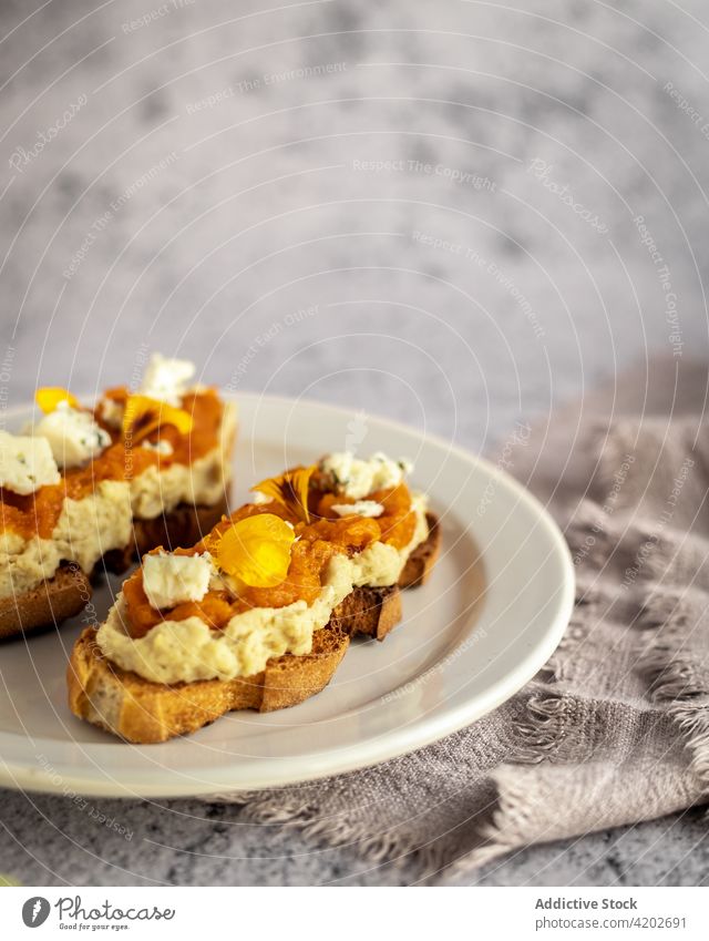 Appetitliche Brottoasts mit Marmelade und Blütenblättern Brotlaib Zuprosten süß frisch lecker Snack geschmackvoll Käse Kürbis Teller gebacken Ordnung Blume