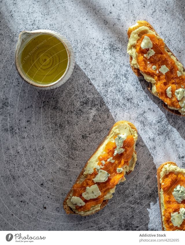 Toasts mit Marmelade und Ziegenkäse auf dem Tisch Zuprosten Brotlaib lecker Snack geschmackvoll selbstgemacht heilsam Käse Kürbis gebacken Ordnung Lebensmittel