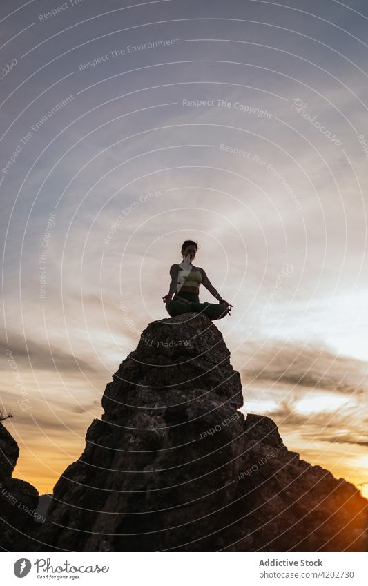 Junge Frau in Lotus-Pose auf einer Bergkuppe Yoga Sonnenuntergang Klippe padmasana Vitalität Zen üben Harmonie beweglich Energie Dämmerung Abend Gleichgewicht