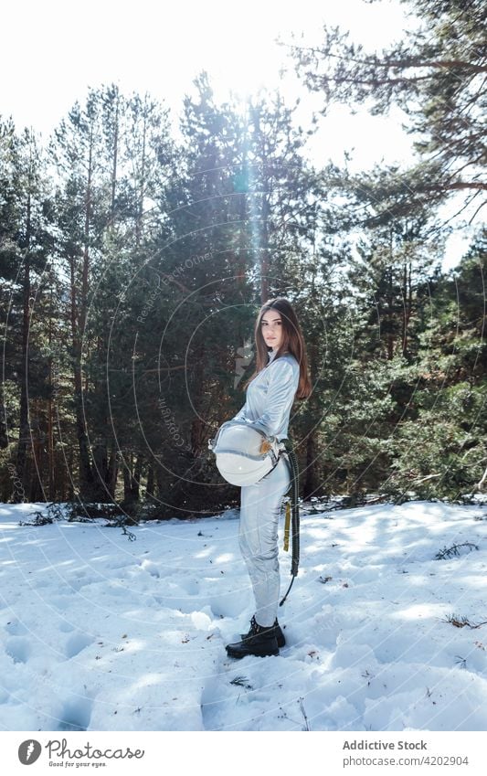 Attraktive Astronautin im verschneiten Wald stehend Frau Schnee Kosmonaut Raumanzug Windstille Winter Astronomie Schutzhelm Entdecker emotionslos professionell