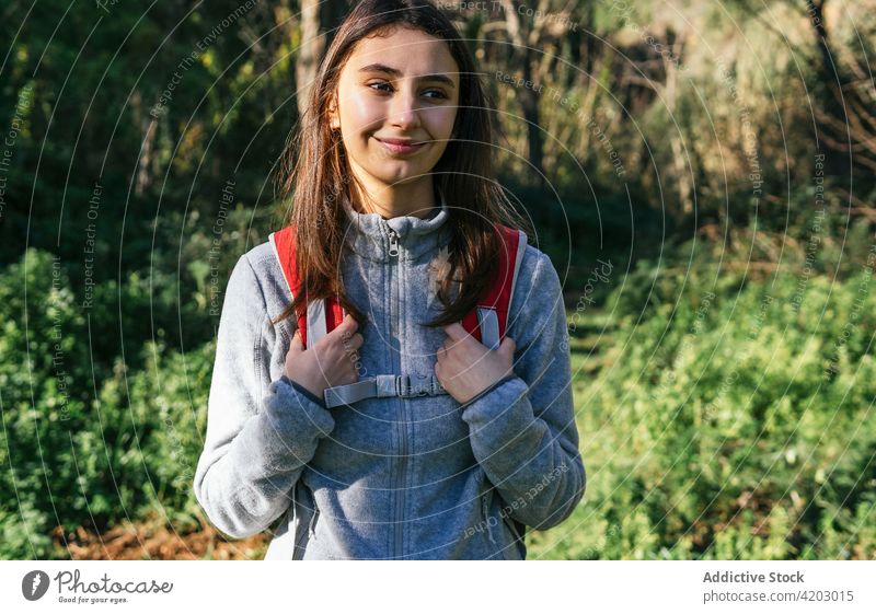 Fröhliche Frau mit Rucksack beim Wandern im Wald Wanderer Glück Sonnenlicht aktiv heiter Natur Lächeln jung Lifestyle Aktivität Erholung Wellness Gesundheit