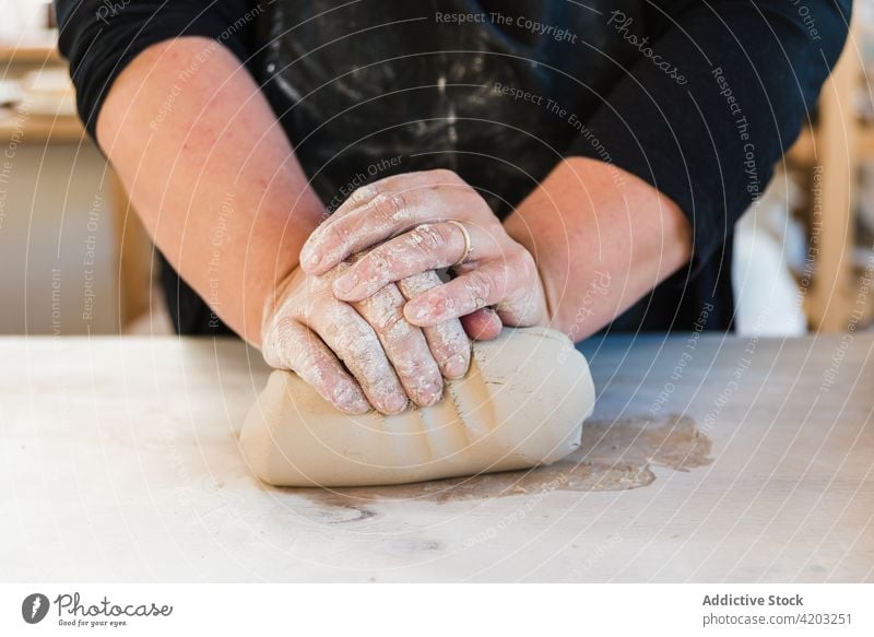 Gesichtslose Frau, die in einer Werkstatt Ton zum Modellieren vorbereitet rollen vorbereiten Meister Fähigkeit Prozess Hobby Handwerkerin Basteln Tisch lässig