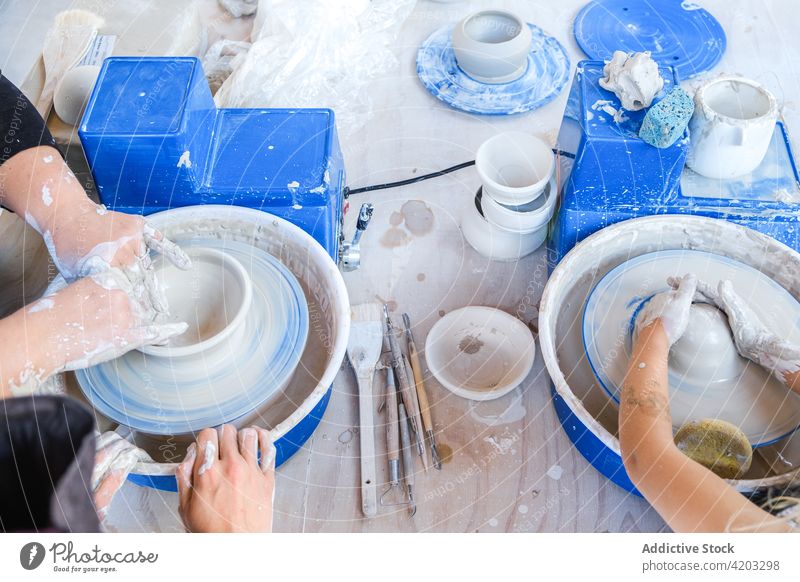 Gesichtslose Frau gibt Kindern Töpferunterricht Töpferwaren Rad Werkstatt Ton Topf Form Mädchen Handwerkerin lässig kreativ Hobby wenig Fähigkeit Tochter Mutter