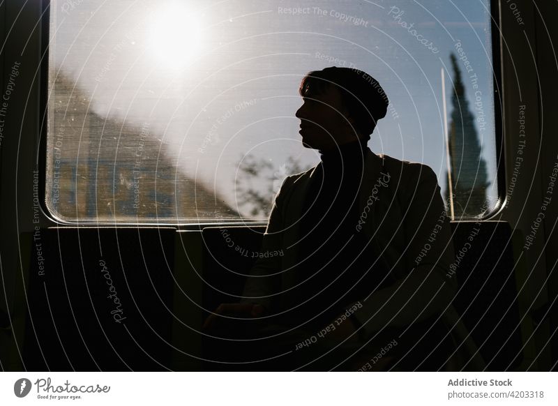 Mann fährt Zug und sitzt am Fenster Schüler Arbeitsweg Mitfahrgelegenheit sonnig Silhouette Passagier Verkehr männlich Fahrzeug Zeitgenosse sitzen Sonne