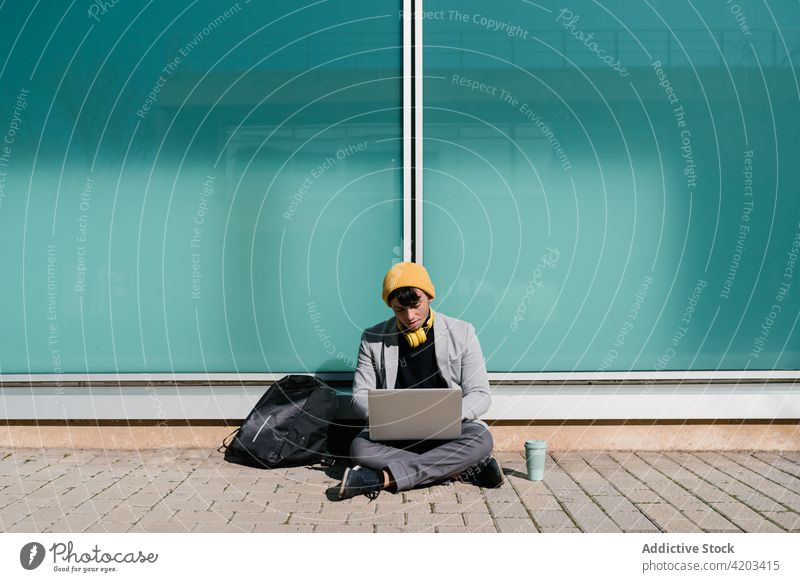 Mann tippt auf Laptop in der Stadt Schüler Tippen Campus Hausaufgabe Projekt Hipster Universität lernen männlich Bildung Imbissbude trinken Straße Apparatur