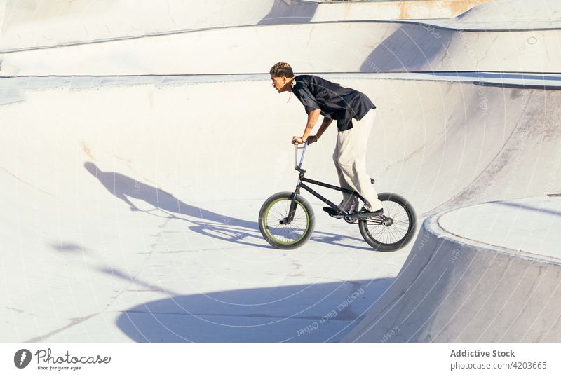 Schwarzer Athlet fährt BMX-Rad auf Plattform bmx subcultre Generation Trick Sport extrem Freestyle Mitfahrgelegenheit Talent Mann Skateplatz Rampe Sportler