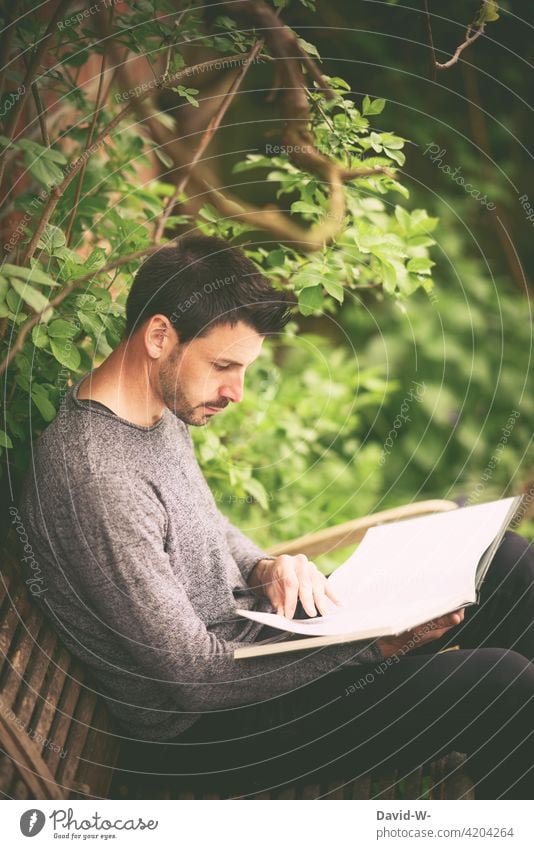 draußen in der Natur auf einer Bank ein Buch lesen Mann ruhe Bildung Leser Naturliebe