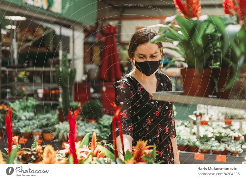 schöne junge Frau kauft Blumen für den Garten Blüte Business kaufen Pflege Zentrum heiter Wahl auserwählend wählte farbenfroh wirtschaftlich Coronavirus Bund 19