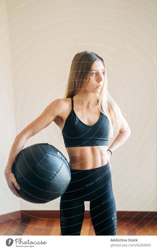 Starke Frau mit Medizinball Sportbekleidung Gerät Übung Training üben Sportkleidung Trainerin Bauchmuskeln Athlet Leggings schwer schwarz Raum Fitness physisch