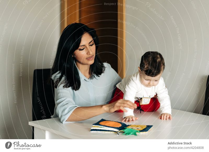 Junge Mutter und kleiner Sohn lesen gemeinsam ein Kinderbuch Familie Buch Elternschaft positiv Mama Mutterschaft Zusammensein Kinderbetreuung Entwicklung