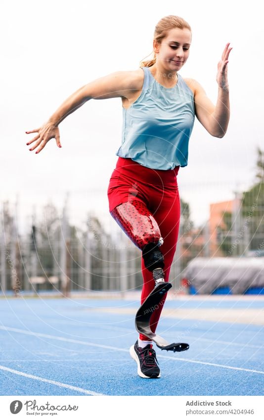 Sportlerin mit bionischer Beinprothese im Stadion laufen Prothesen Läufer paralympisch Athlet Training Energie Sprinter Frau Bionik professionell Rennbahn