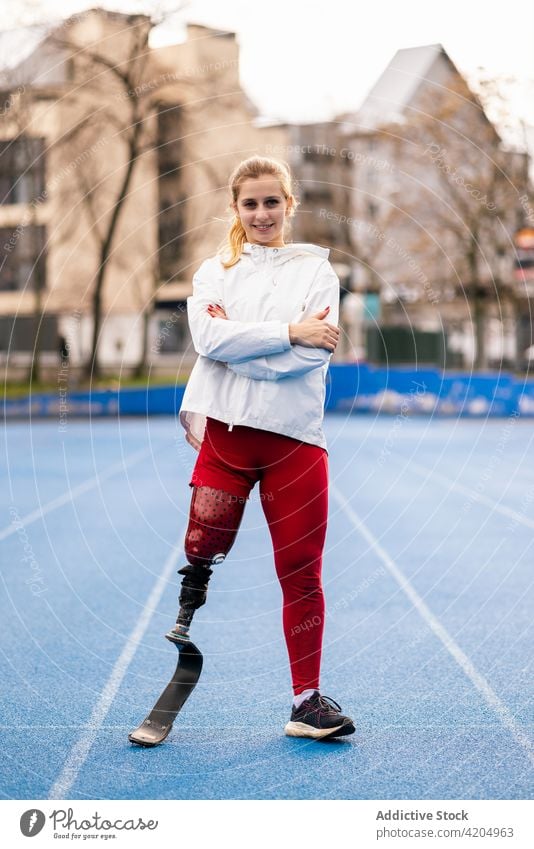 Fröhliche Sportlerin lächelt und schaut in die Kamera Athlet Lächeln Inhalt sonnig Stadion Sportbekleidung professionell Training passen Frau Gesundheit Fitness