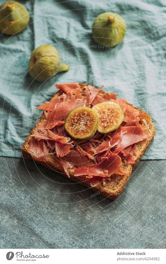 Leckerer Toast mit Iberico-Schinken, Käse und frischen Feigen auf dem blauen Tischtuch iberisch Zuprosten Amuse-Gueule Bruschetta Feinschmecker Snack