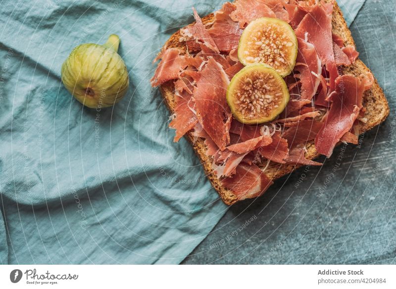 Leckerer Toast mit Iberico-Schinken, Käse und frischen Feigen auf dem blauen Tischtuch iberisch Zuprosten Amuse-Gueule Bruschetta Feinschmecker Snack