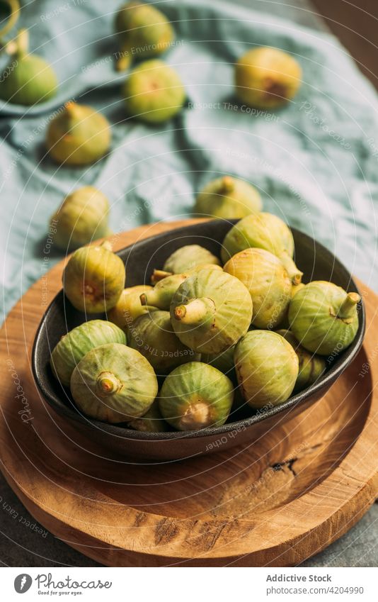 Frische und reife süße grüne Feigen auf dem Holzteller Tisch Frucht Schalen & Schüsseln organisch Lebensmittel Diät Natur Gesundheit saftig frisch roh blau