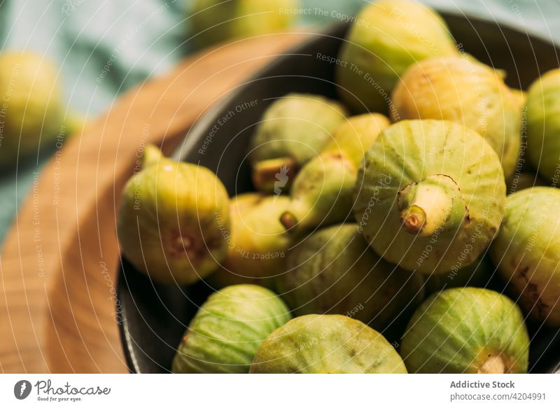 Frische und reife süße grüne Feigen auf dem Holzteller Tisch Frucht Schalen & Schüsseln organisch Lebensmittel Diät Natur Gesundheit saftig frisch roh blau