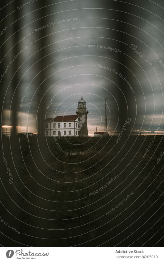 Alter Leuchtturm gegen bewölkten Himmel am Abend Leuchtfeuer Sonnenuntergang wolkig Turm Gebäude navigieren Dämmerung Abenddämmerung Konstruktion Licht glühen