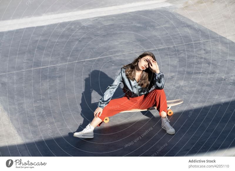 Trendige Sportlerin auf Longboard im Skatepark Frau Mode Stil cool Individualität Stirn berühren tausendjährig Skateplatz Rampe Schnüffler selbstsicher