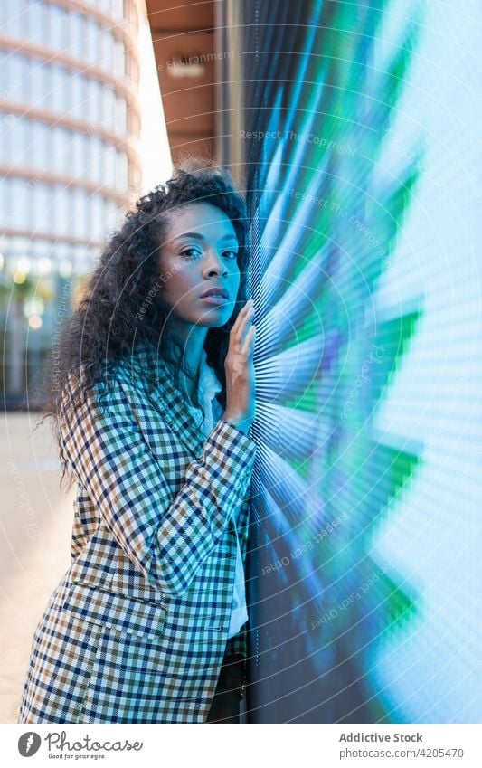 Nachdenkliche Frau in der Nähe von Neonlicht auf der Straße neonfarbig verträumt Stadt Windstille besinnlich nachdenklich Zeichen nachdenken Vorschein