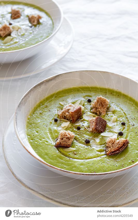 Schüssel mit leckerer Zucchinicremesuppe auf dem Tisch Suppe Sahne dienen Schalen & Schüsseln Crouton geschmackvoll Mahlzeit Lebensmittel Mittagessen Speise