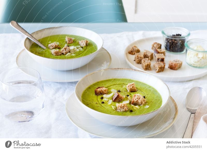 Schalen mit leckerer Zucchinicremesuppe auf dem Tisch Suppe Sahne dienen Schalen & Schüsseln Crouton geschmackvoll Mahlzeit Lebensmittel Mittagessen Speise