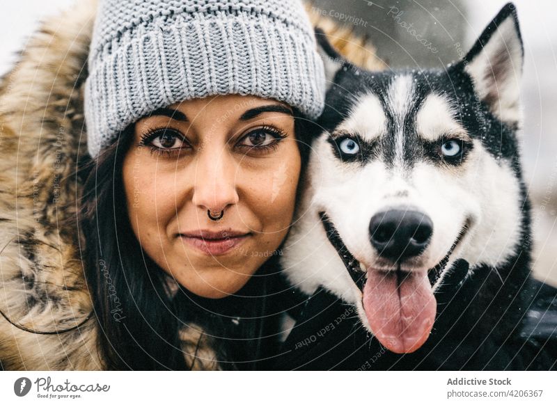 Frau umarmt Hund im Winterwald Husky Umarmung Wald Glück Besitzer Haustier jung Welpe gehorsam Schnee warme Kleidung loyal Tier Baum Umarmen Waldgebiet niedlich