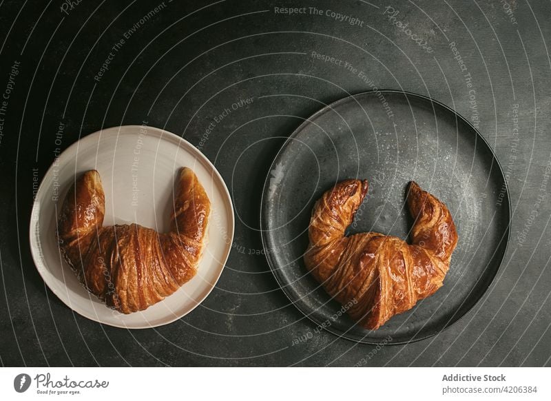 Gebackene Croissants auf Tellern auf dem Tisch gebacken Brot Kulisse Lebensmittel frisch Bäckerei Brötchen Gebäck Frühstück Form verschiedene anders Küche