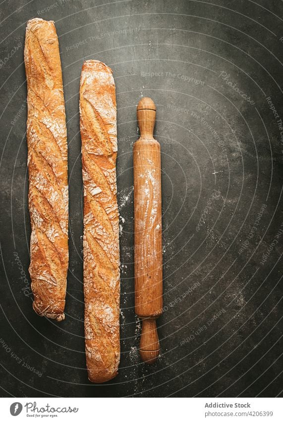 Frische Brotlaibe und Nudelholz auf dem Tisch gebacken Kulisse verschiedene rustikal Lebensmittel frisch Bäckerei Baguette rund Mehl anders natürlich Küche