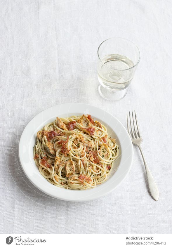 Nahaufnahme eines Tellers mit Spaghetti und Artischocken von oben gesehen Lebensmittel frisch Käse Paprika Schinken Gemüse Spätzle Prosciutto Vegetarier