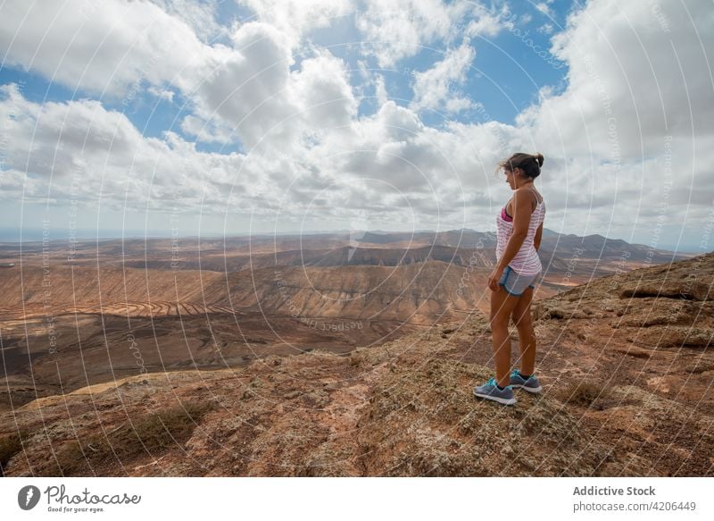 Frau steht auf einer Bergkuppe und bewundert die hügelige Landschaft Reisender Wanderung Hochland Tal Natur Hügel felsig Wanderer lässig reisen Berge u. Gebirge