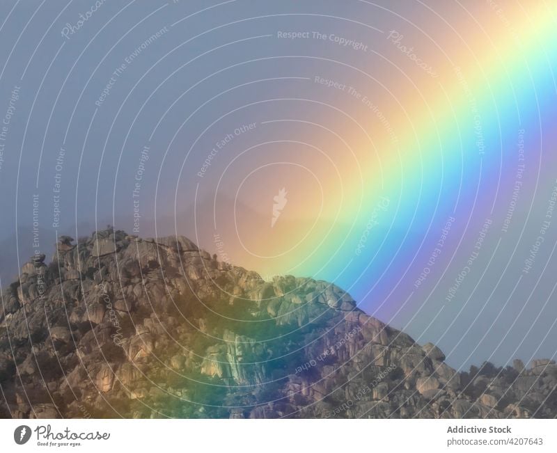 Heller Regenbogen über Bergkette Himmel Berge u. Gebirge Kamm Bogen Landschaft Natur Umwelt irisierend Ambitus pulsierend hell lebhaft bedeckt Nebel Strahlen