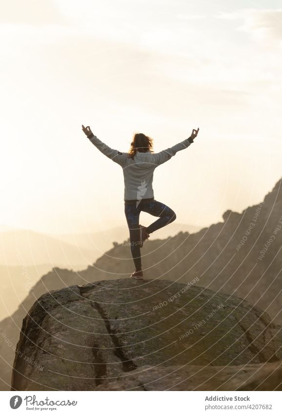 Frau in Vrksasana auf einer Bergkuppe Yoga Baum mit Armen nach oben Pose Erholung meditieren Natur beweglich selbstbewusst Berge u. Gebirge vrksasana