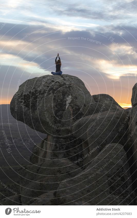 Anonyme Frau in Lotus-Pose meditierend auf einer Bergkuppe Yoga Sonnenuntergang Klippe Meditation padmasana Vitalität Zen üben Harmonie beweglich Energie