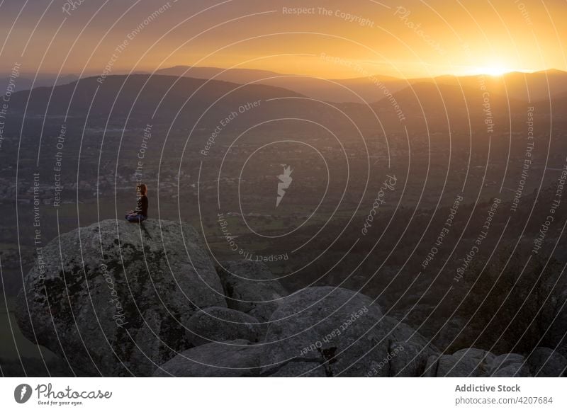 Junge Frau in Lotus-Pose meditiert auf einer Bergkuppe Yoga Sonnenuntergang Klippe Meditation padmasana Vitalität Zen üben Harmonie beweglich meditierend