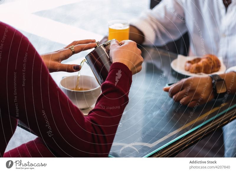 Gemischtrassiges Paar frühstückt in einem Cafe Café Frühstück Zusammensein Tee trinken Morgen eingießen Tasse Partnerschaft Liebe Heißgetränk aromatisch