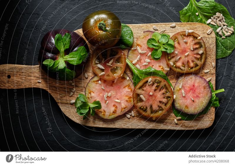 Schwarze Tomaten und Minze auf dem Schneidebrett schwarz frisch Gemüse Scheibe Lebensmittel natürlich vorbereiten Gesundheit Mahlzeit Bestandteil organisch