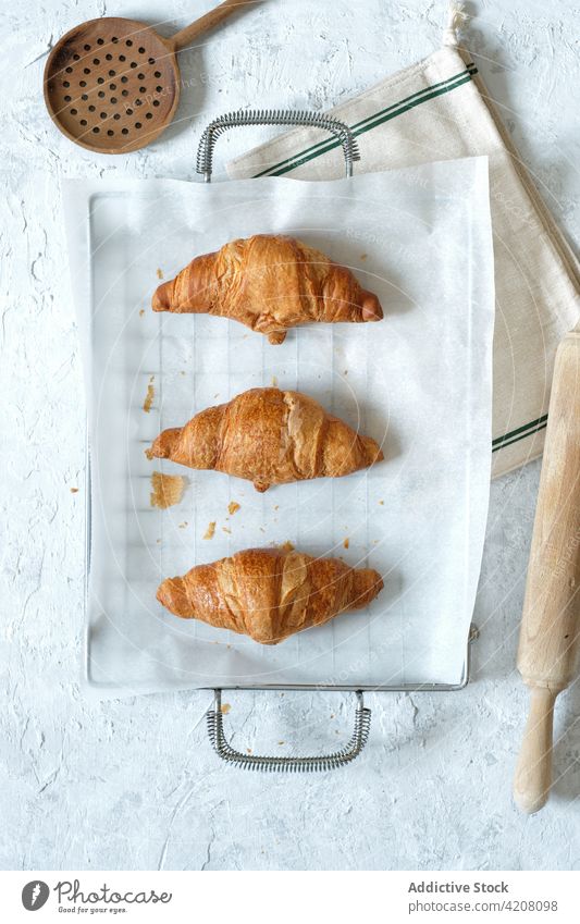 Appetitliche süße Croissants auf dem Tisch Dessert selbstgemacht Backpapier Küche Gebäck frisch gebacken Bäckerei Tablett lecker Metall appetitlich Ernährung