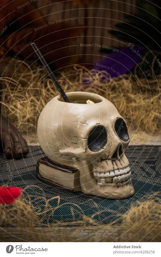 Totenkopf Tiki Becher mit Cocktail tiki Schädel Getränk Alkohol trinken Schnaps trocknen Gras hölzern Zaun Blatt farbenfroh Stroh Eis Erfrischung Glaswaren