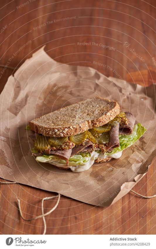 Nahaufnahme eines leckeren Sandwiches mit Pastrami, Salat, Schinken und Gurken Mittagessen Käse Belegtes Brot Pickles Fleisch Lebensmittel Snack Rindfleisch