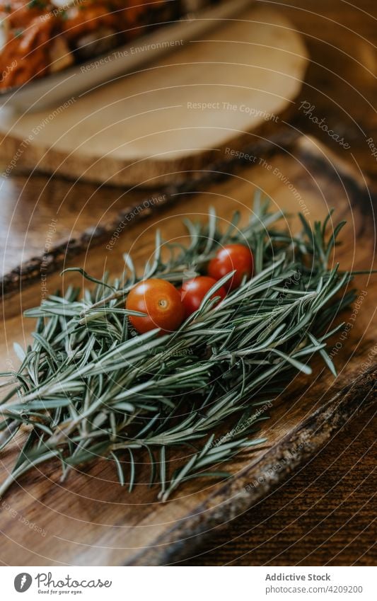 Frische Kirschtomaten mit aromatischen Rosmarinzweigen Zweig gesunde Ernährung Gemüse Kraut natürlich organisch Aroma Bestandteil Teller rustikal Stil Nährstoff