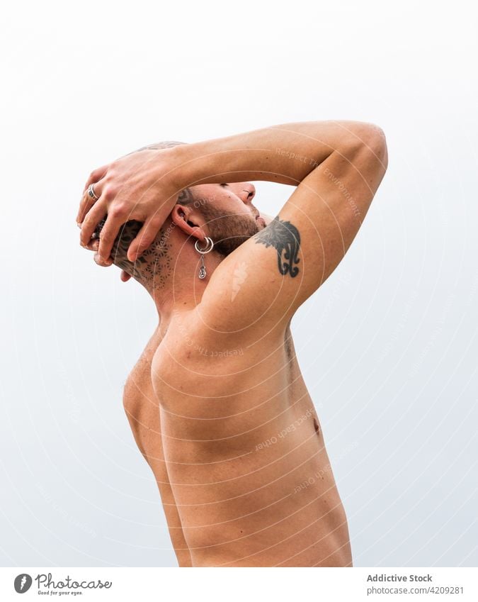 Ruhiger Mann mit tätowiertem Kopf vor See und Bergen Tattoo Windstille ruhig Natur Berge u. Gebirge Mandala Umwelt kahl männlich Fluss Augen geschlossen wolkig