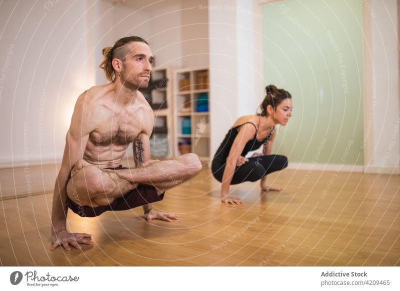 Trainer übt Skalenposition mit Frau Mann Trainerin Skala Yoga üben Gleichgewicht Stressabbau Erholung Zen männlich Sportkleidung mental Körperpflege