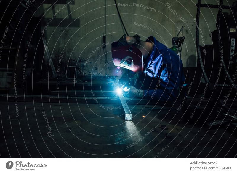 Anonymer Arbeiter beim Schweißen einer Metallkonstruktion in einer Werkstatt Person Schweißnaht Handwerker Funken Konstruktion Gerät professionell Ingenieur