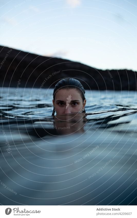 Frau schwimmt im Meer gegen eine Felsklippe Tourist Wasser MEER felsig Klippe Hobby blau Ausflug Urlaub Reisender Sauberkeit reisen Erholung erkunden Stein