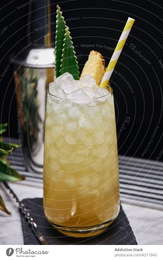 Glas mit Ananas-Cocktail beim Shaker Eis Schiefer Würfel Stroh Schüttler Abfertigungsschalter Löffel Blatt Glaswaren kreativ frisch Papier Untersetzer exotisch