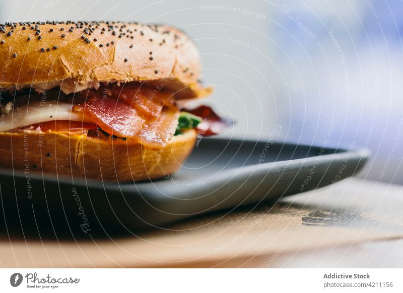 Leckeres Bagel-Sandwich auf dem Tisch im Café Belegtes Brot Fleisch dienen geschmackvoll Hähnchen Speck appetitlich Lebensmittel Mahlzeit lecker Salatbeilage